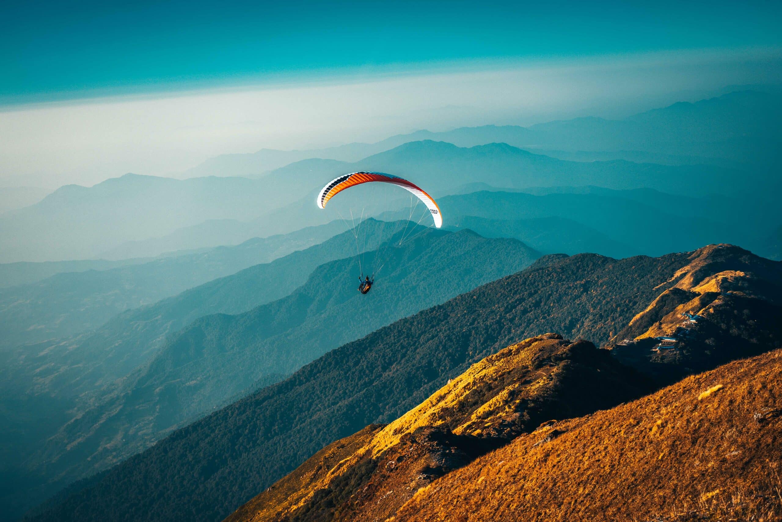 A paraglider against a scenic mountain view