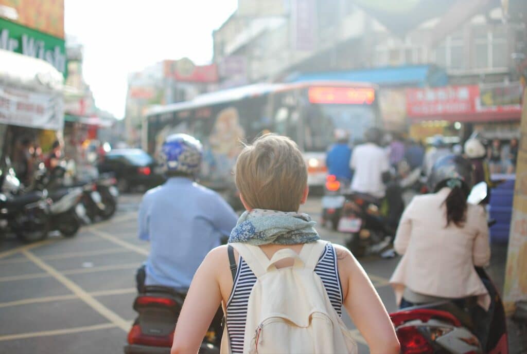 A traveler facing the bustling roads and busy locals of her destination.