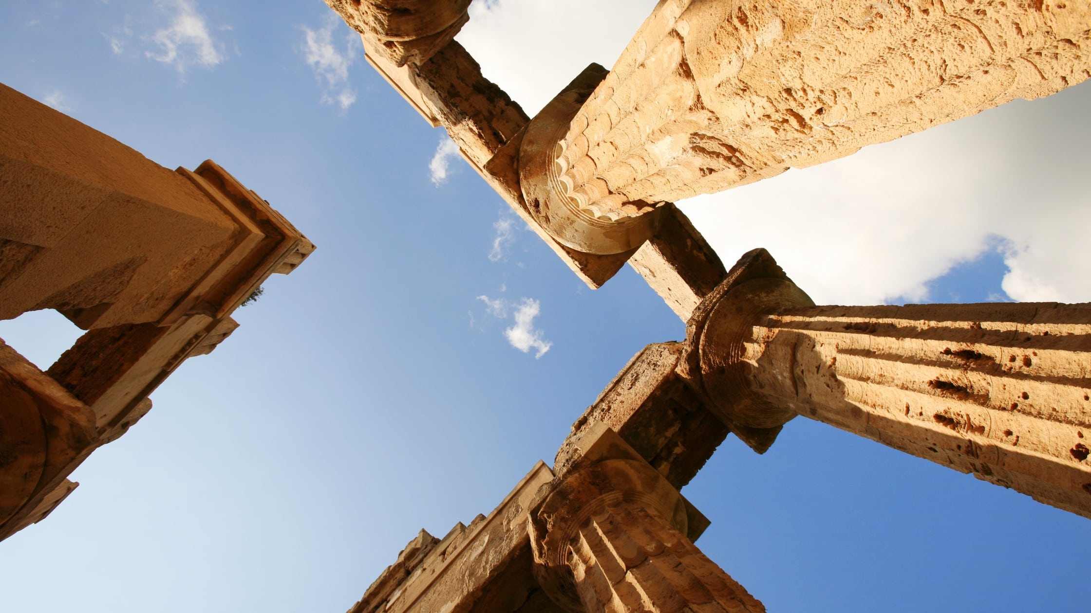A worm’s eye view of structural ruins, depicting Greek culture, architecture, and history.