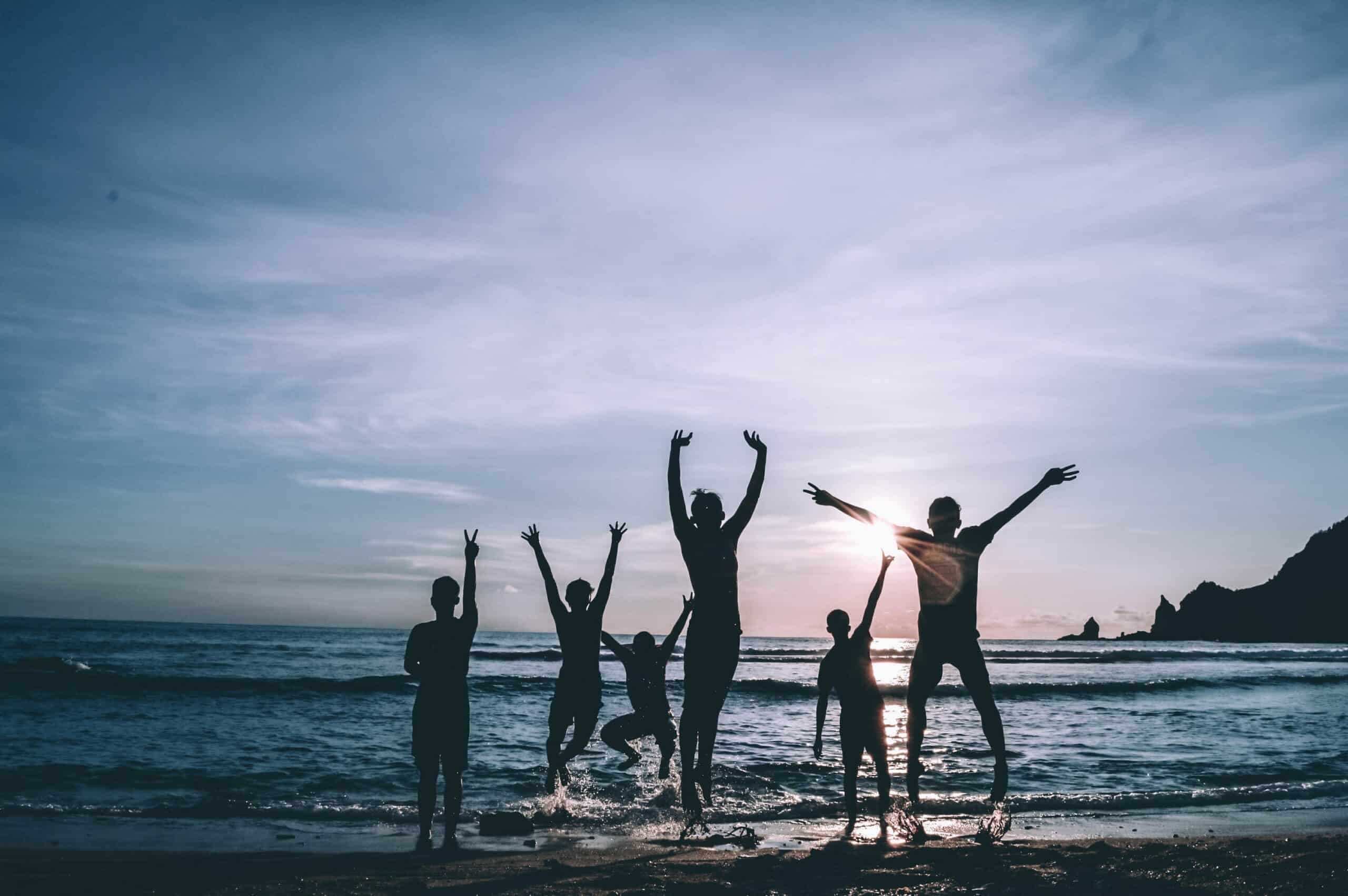 Silhouette of five people standing on the seashore