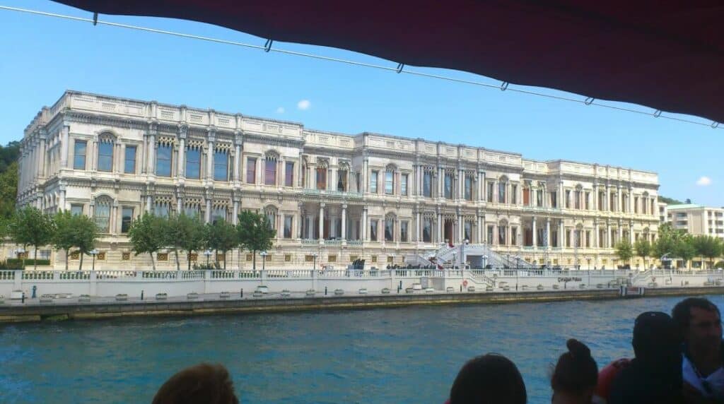 Tourists cruising Istanbul and gazing at the magnificent facade of the Ciragan Palace. 