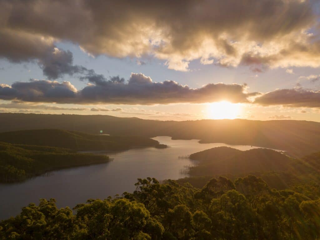 Aerial view of the river between the hills over the setting sun in Australia