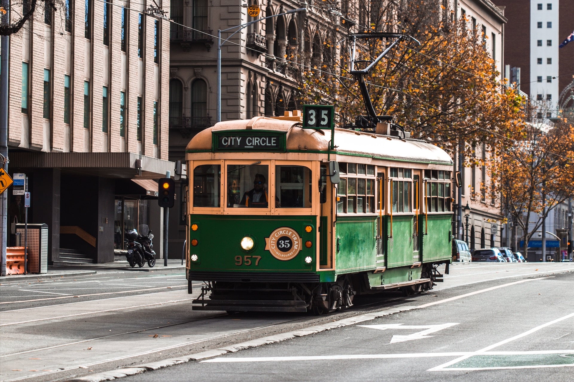 A green and yellow tram on the road, a common mode of transportation for taking Melbourne day trips